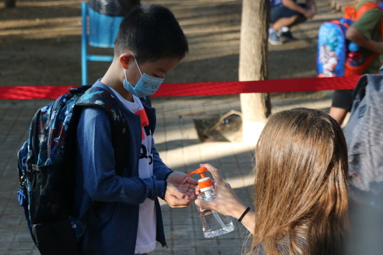 A student using hand sanitizer at a Barcelona school (by Miquel Codolar)